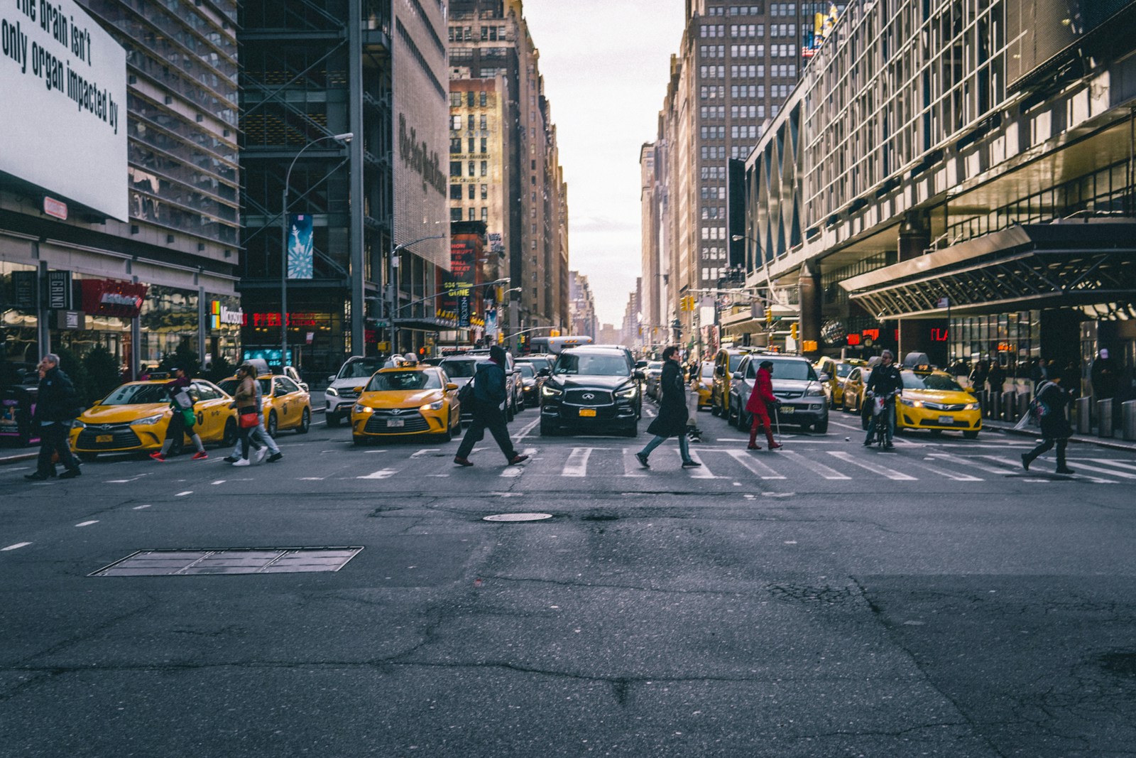 Pedestrians and yellow taxis crossing an NYC intersection